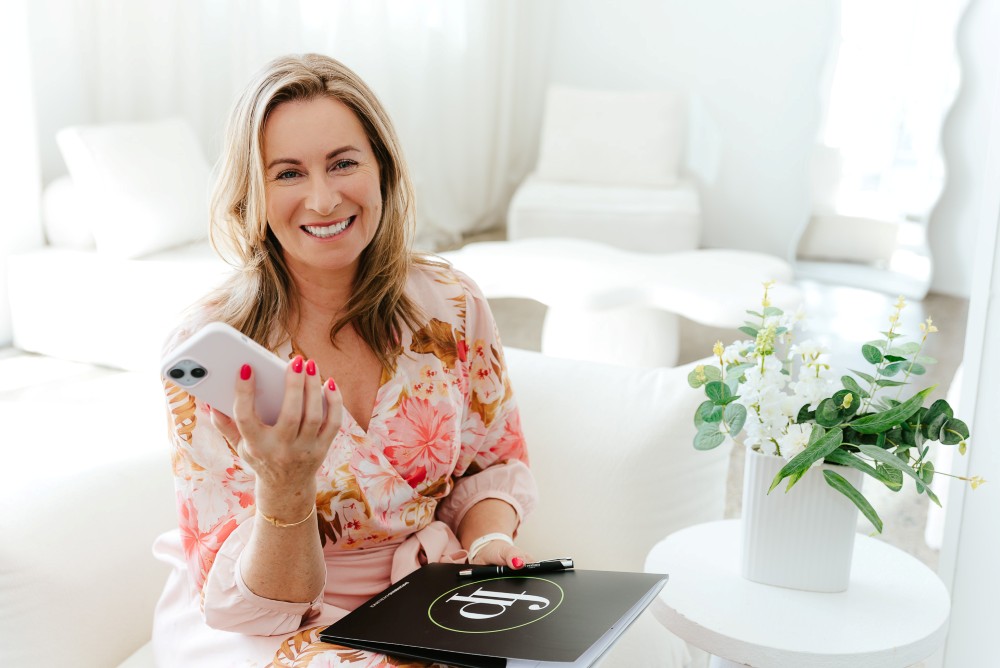 Real Estate Agent holding phone and paperwork in her hands