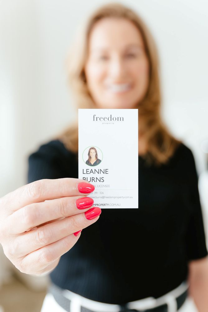 Woman holding up her business card towards the camera